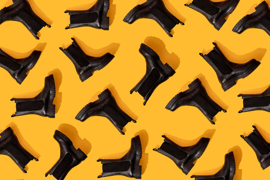 Pattern of black leather boots against yellow background
