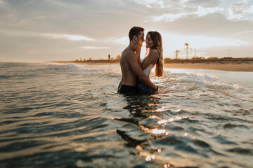 Romantic couple standing in water at beach