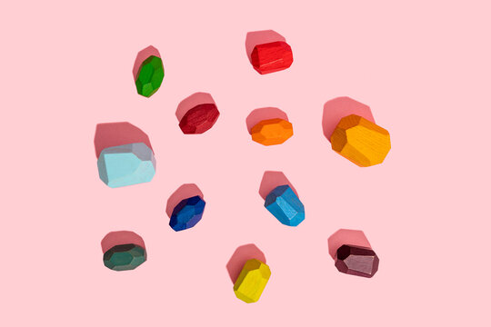 Multi colored wooden blocks against pink background