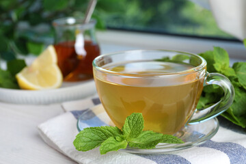 Fresh green tea with mint leaves on table