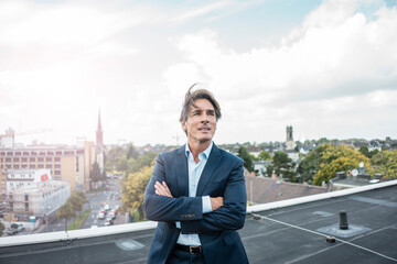 Businessman standing on roof in the city