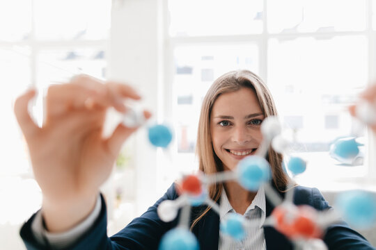 Female scientist studying molecule model