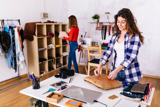 Fashion designer wrapping a package in studio