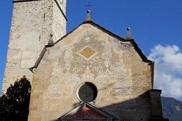 la facciata decorata dell'antica parrocchiale dell'Assunta a Baselga di Pinè; Trentino
