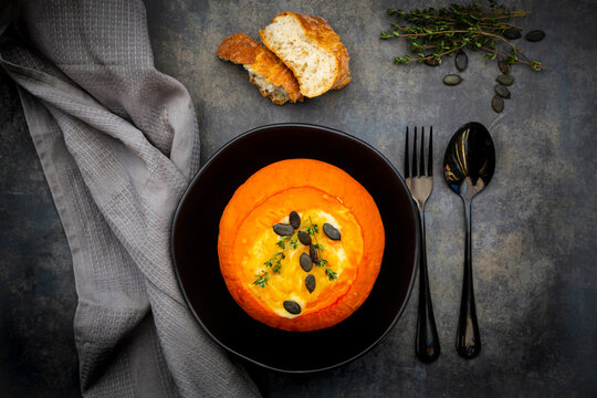 Studio shot of Hokkaido pumpkin stuffed with&Ocirc;&oslash;&Omega;camembert&Ocirc;&oslash;&Omega;cheese, thyme and pumpkin seeds