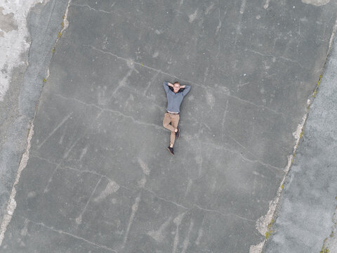 Young businessman relaxing on tarmac, quadcopter viewquadcopter