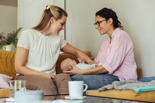 Midwife and mother giving newborn baby a belly massage to help with digestion