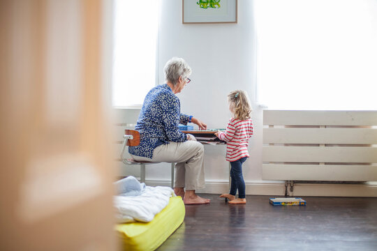 Grandmother and granddaughter playing together at table