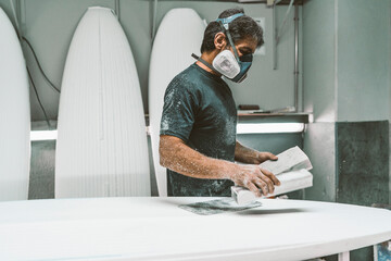Mature man wearing protective face mask looking down while standing indoors