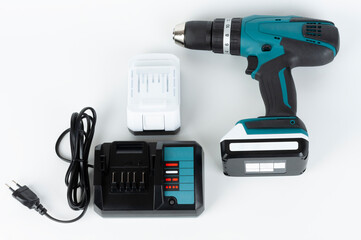 Cordless hammer screwdriver drill, battery charger and second battery on white background. Studio...