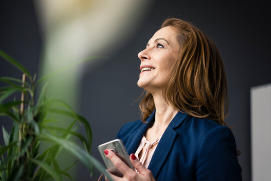 Mature businesswoman working in sustainable office, using digital tablet