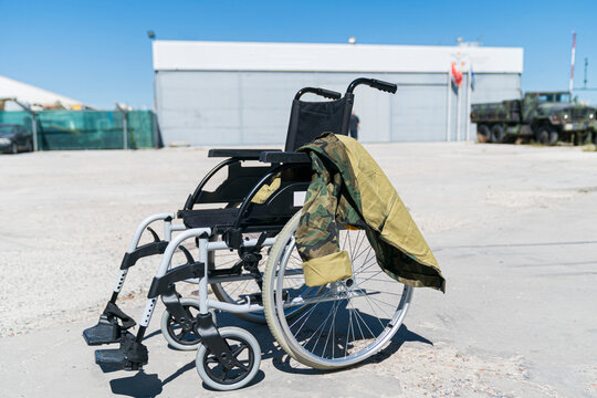 Military uniform on empty wheelchair at military base during sunny day