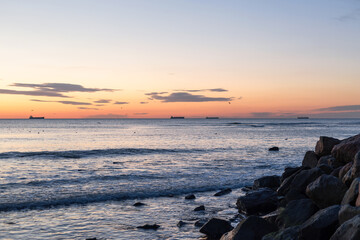 Fototapeta na wymiar Sea rocks and blue sea and sunrise in Odessa on the beach