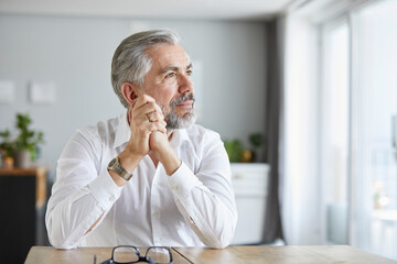 Portrait of pensive mature man at home