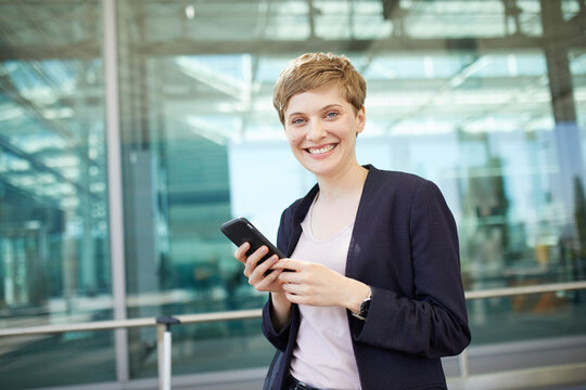 Portrait of blond businesswoman using smartphone