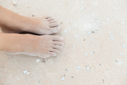 Cropped image of female feet on sand