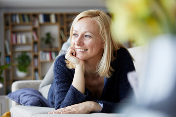 Woman relaxing at home, sitting on couch