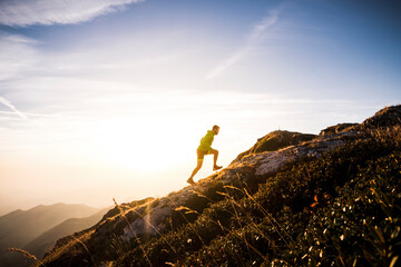 Italy, man running on mountain trail