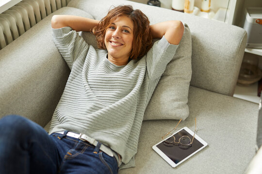Portrait of smiling mature woman relaxing on couch