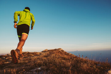 Italy, man running on mountain trail