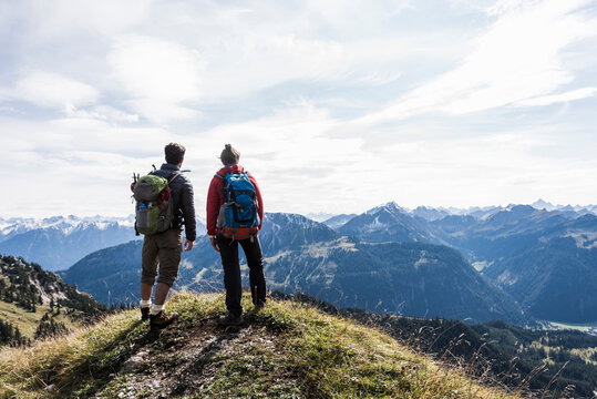 Austria, Tyrol, young couple standing in mountainscape looking at view