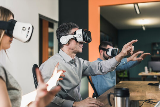 Colleagues wearing VR glasses in office