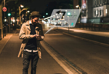Young man on street at night with data emerging from smartphone