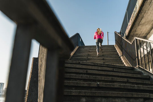 Young woman running up stairs