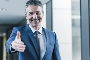 Portrait of smiling businessman about to shake hands