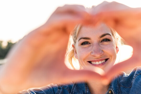 Woman making heart shape with hands and fingers