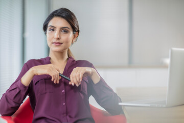 Portrait of confident businesswoman with laptop in office