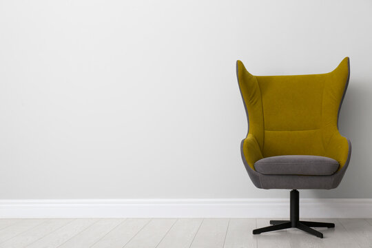 Comfortable office chair near light wall indoors. Space for text