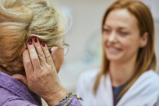 Female doctor and senior woman with hearing aid