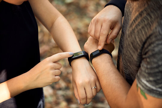 Close-up of sporty couple checking smartwatches