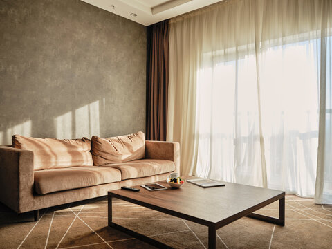 Wooden coffee table with empty sofa in luxury hotel room