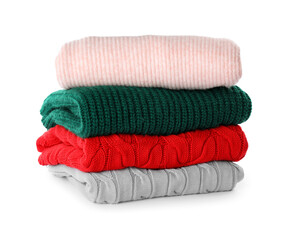 Stack of different warm sweaters isolated on white