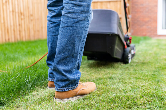 Man standing with lawn mower at backyard