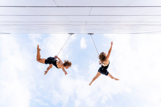Aerial dancers with hand raised dancing against sky