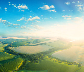 Fototapeta premium Aerial view of the sunset over the green fields.