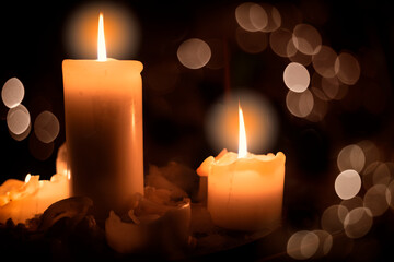 Three big candles on a black background, close-up, selective focus.