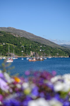UK, Scotland, Ullapool, Boats sailing near shore of Loch Broom