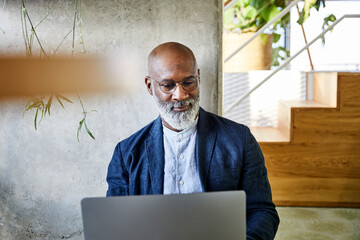 Smiling man working on laptop at home