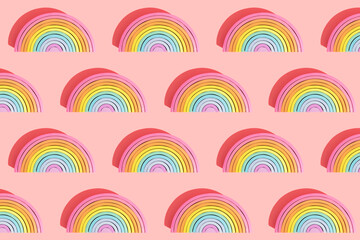 Multiple image of colorful wooden rainbow toys on pink background