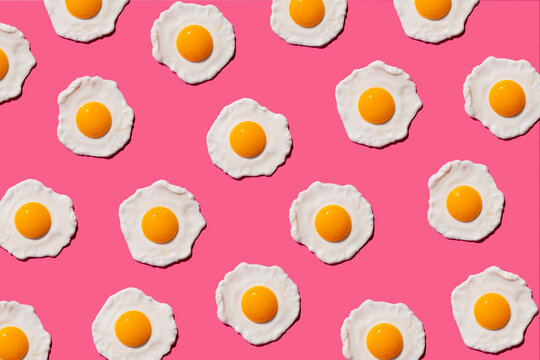 Pattern of fried eggs against pink background
