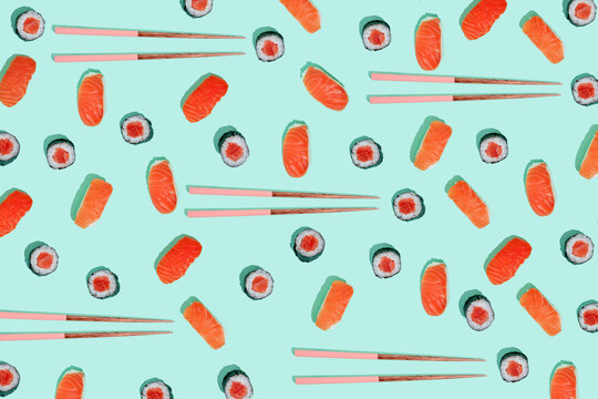 California roll and salman sushi nigiri with chopsticks on mint green background