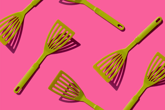 Pattern of green spatulas against pink background