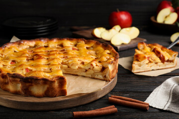 Traditional apple pie on black wooden table