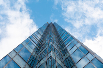 Tall modern office glass skyscraper against blue sky, London, UK