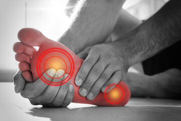 Man suffering from foot pain at home, closeup