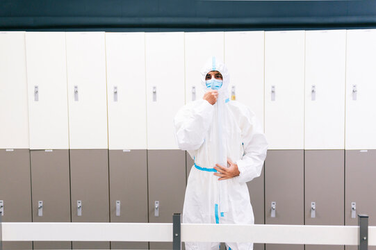 Healthcare man standing against locker in hospital